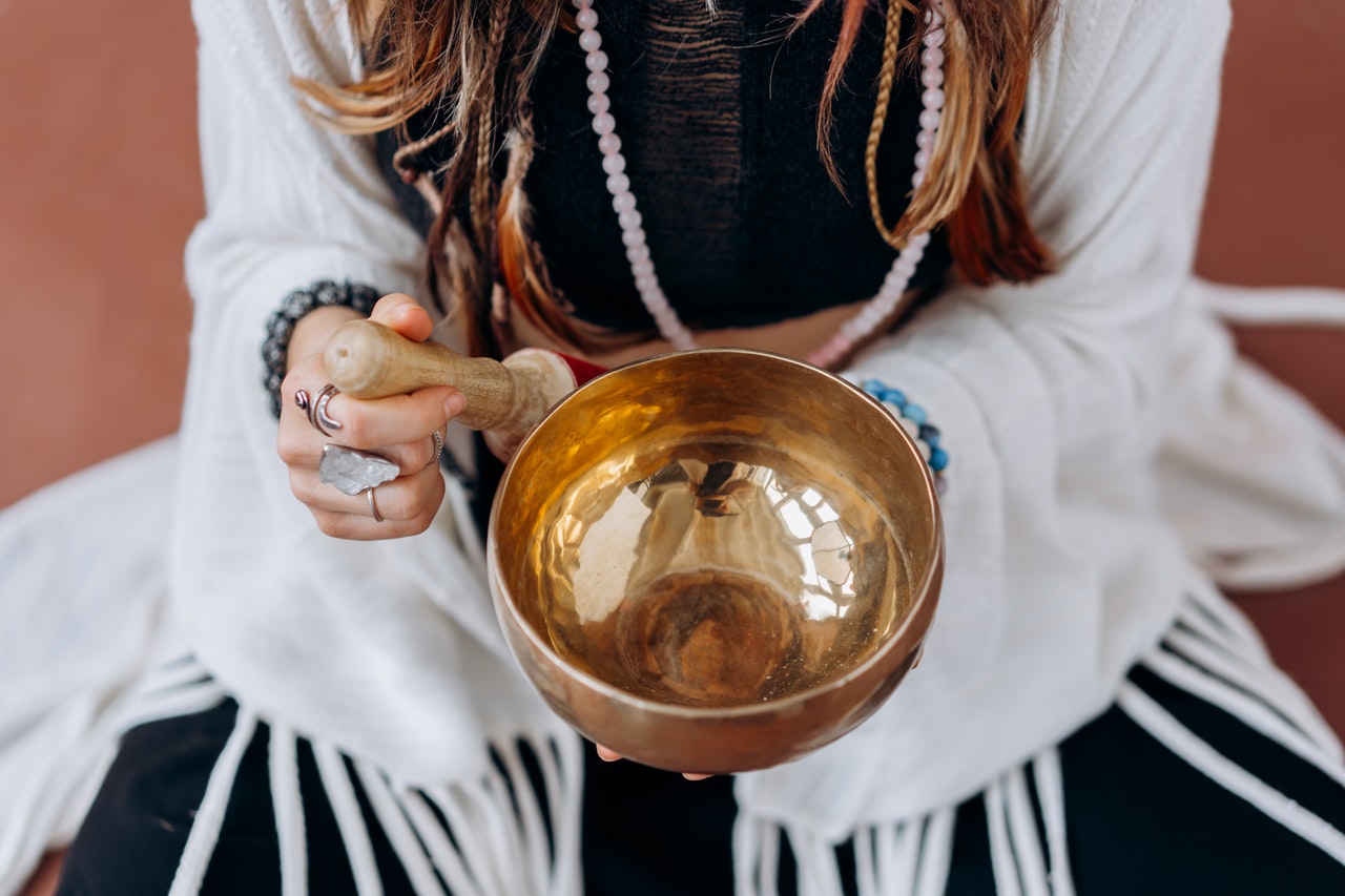 Woman in White Long Sleeve Shirt Holding Gold Round Bowl Can Reiki Be Used For