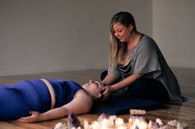 A woman reiki practitioner giving reiki attunement to another woman patient
