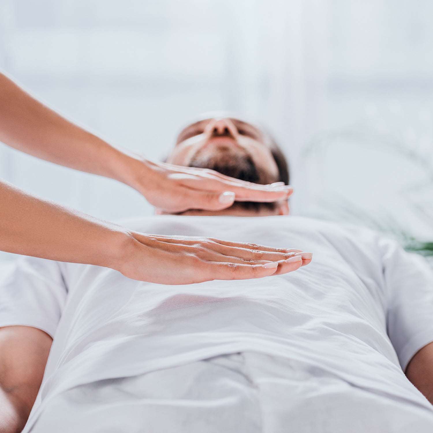 Reiki done on a man wearing white clothes
